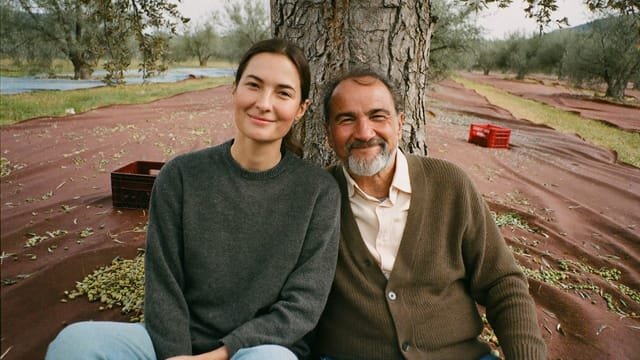 Maria and Francisco seated under an olive tree